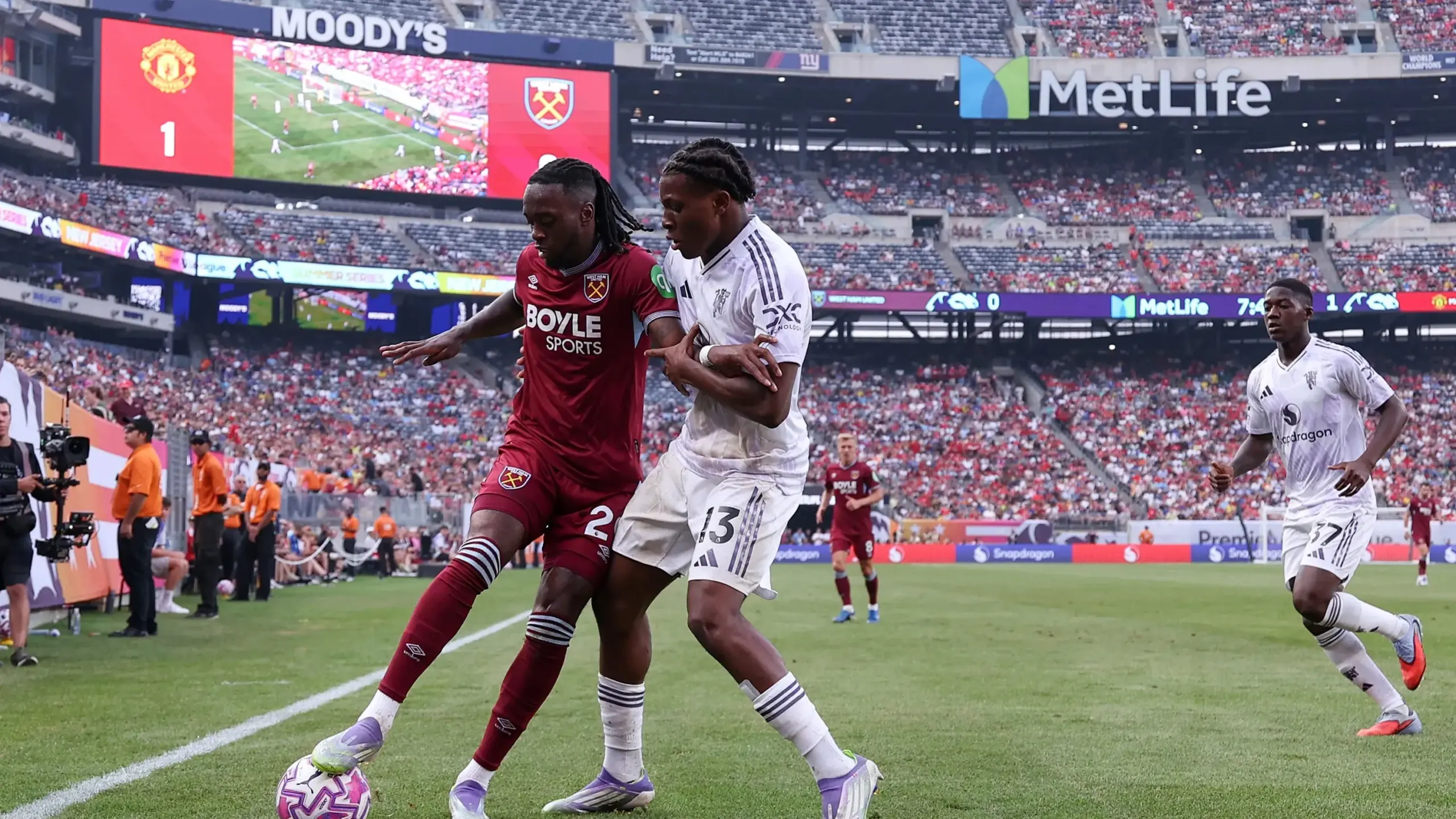 Aaron Wan-Bissaka #29 of West Ham United and Patrick Dorgu #13 of Manchester United battle for possession