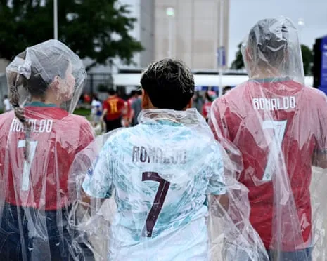 Portugal fans wear ponchos and Cristiano Ronaldo shirts