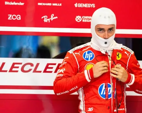 Charles Leclerc in a red Ferrari suit and white balaclava zips up his suit