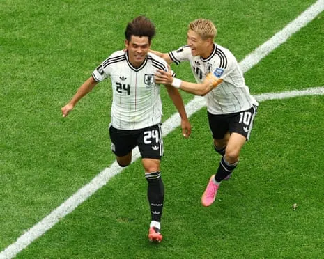 Japan's Kaishu Sano celebrates scoring their first goal with Ritsu Doan.