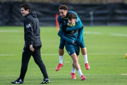 Andoni Iraola walks past Milos Kérkez as he gives Marcus Tavernier a piggyback during a training session at Bournemouth