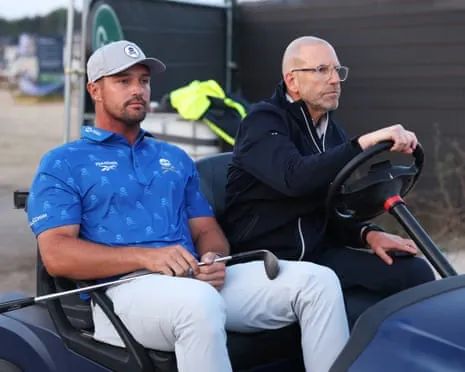 Bryson DeChambeau is driven back to the fifth hole by an R&A official
